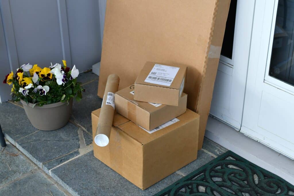 Boxes Packages mail parcels from online orders on a front porch after being delivered