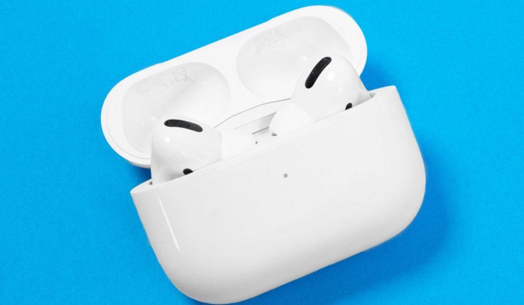 New unpacked wireless headphones Apple AirPods Pro with opened rechargeable case and box on blue