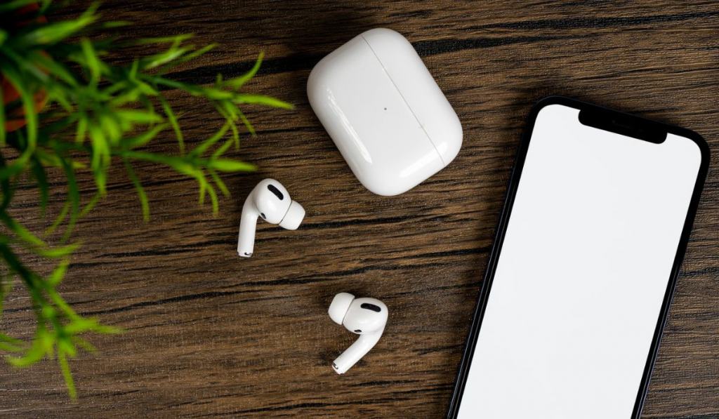 Smartphone with white on display, bluetooth headphones on wood table