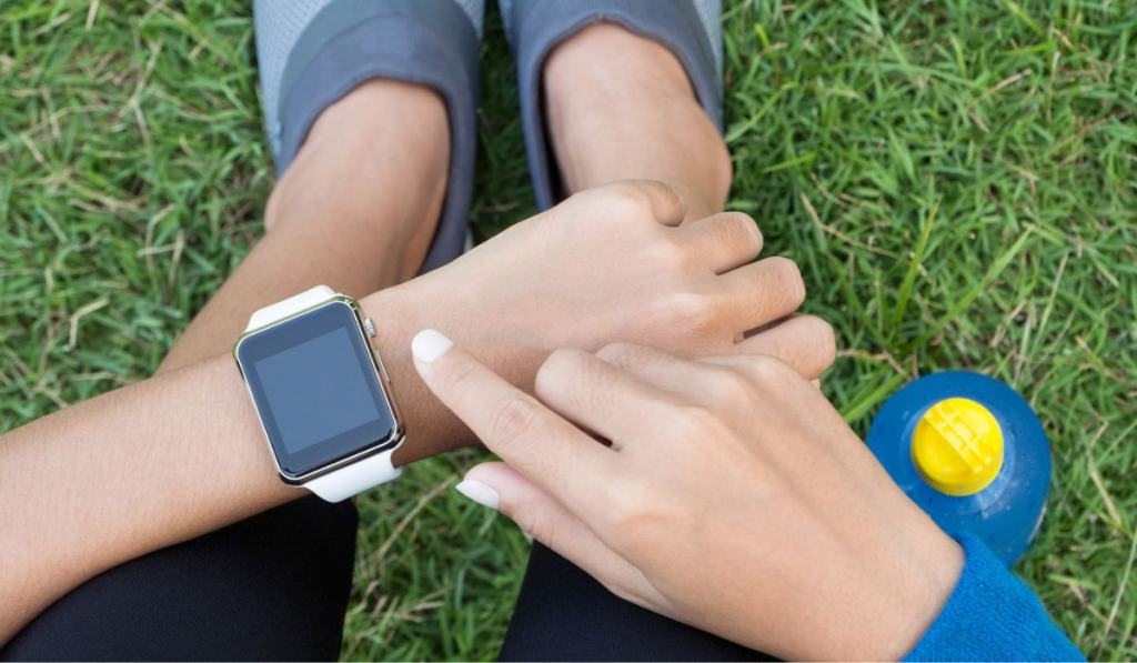 Athletic woman using smartwatch on top