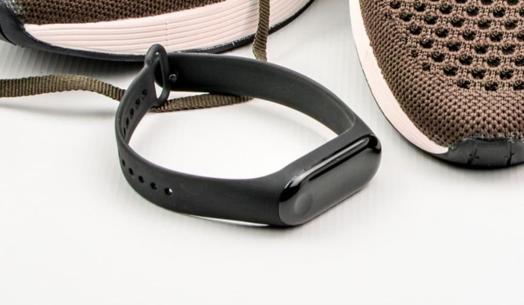 Black fitness tracker with metal band on a wrist 