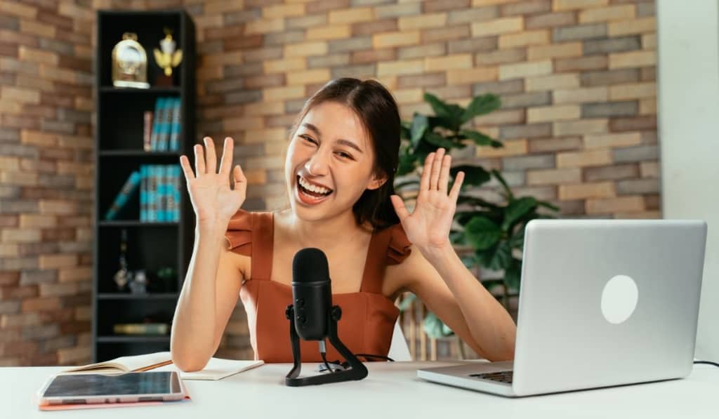 Cheerful blogger using mic for podcast 