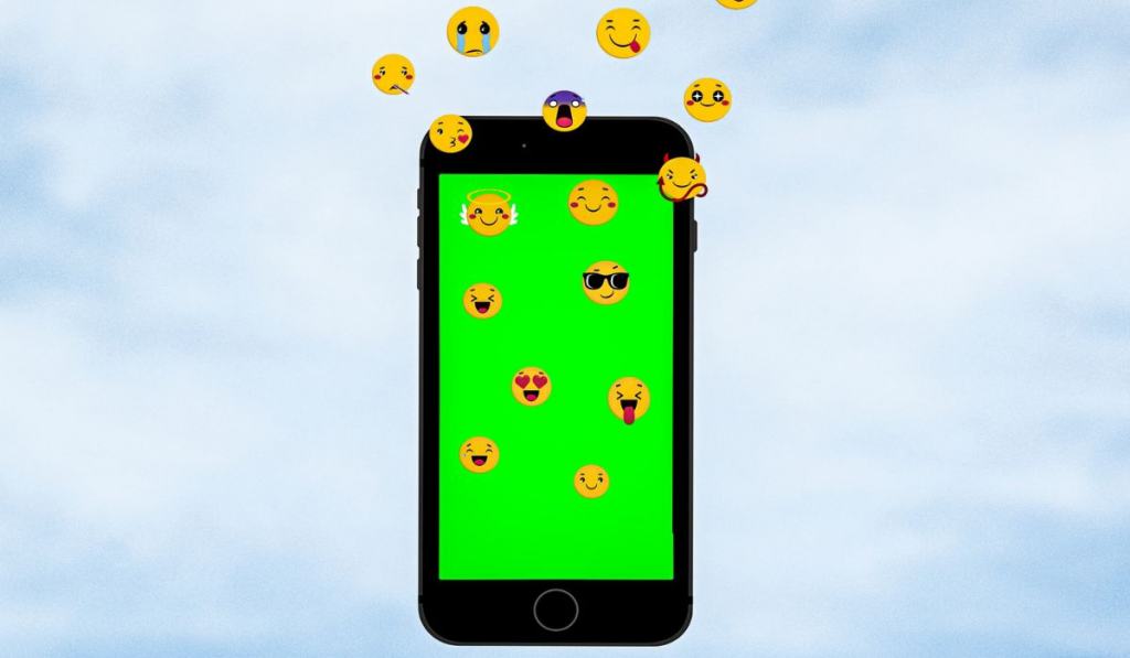 Emoji icons running out from a green screen smartphone on bright blue sky background