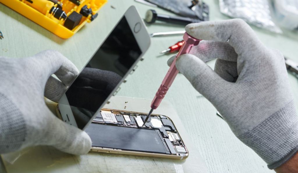 Repairman disassembling smartphone for maintenance
