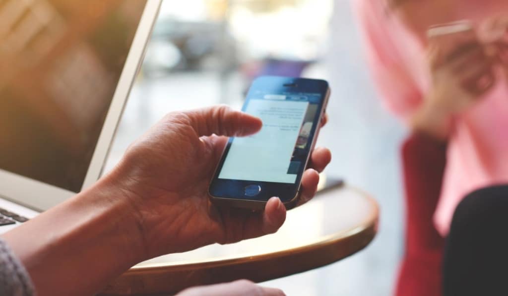 Closeup of young person is searching information in network via cellphone