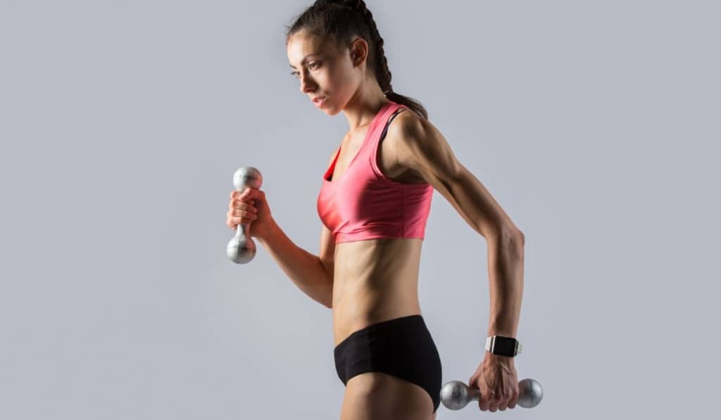 Fitness girl working out with weights 