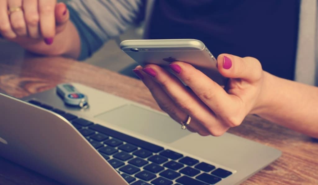 Iphone and computer on womans hand