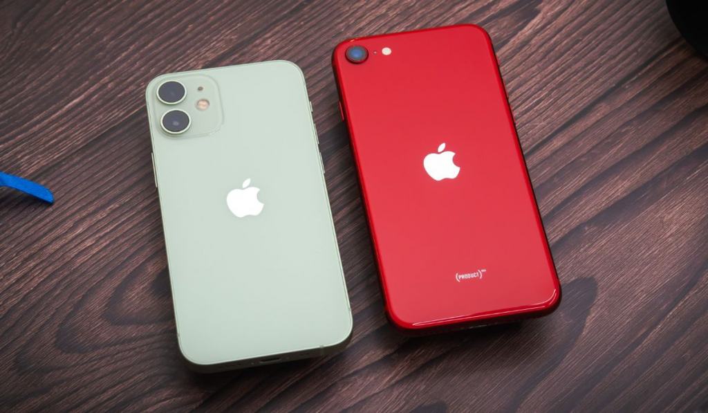 Green iPhone 12 Mini and Red iPhone SE 2nd Gen (2020) on a wooden table