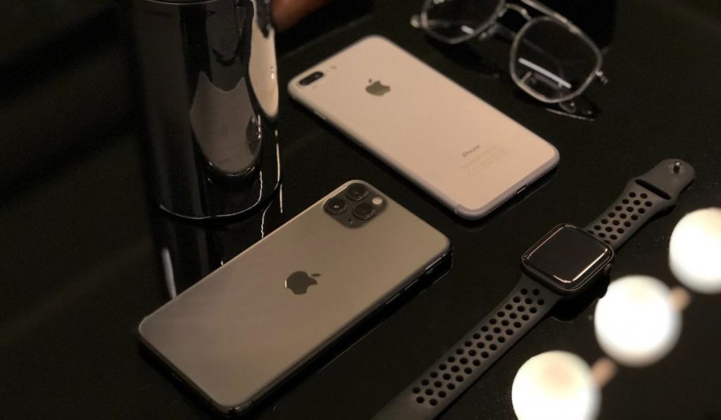 Objects and iphones laying on a black glass table