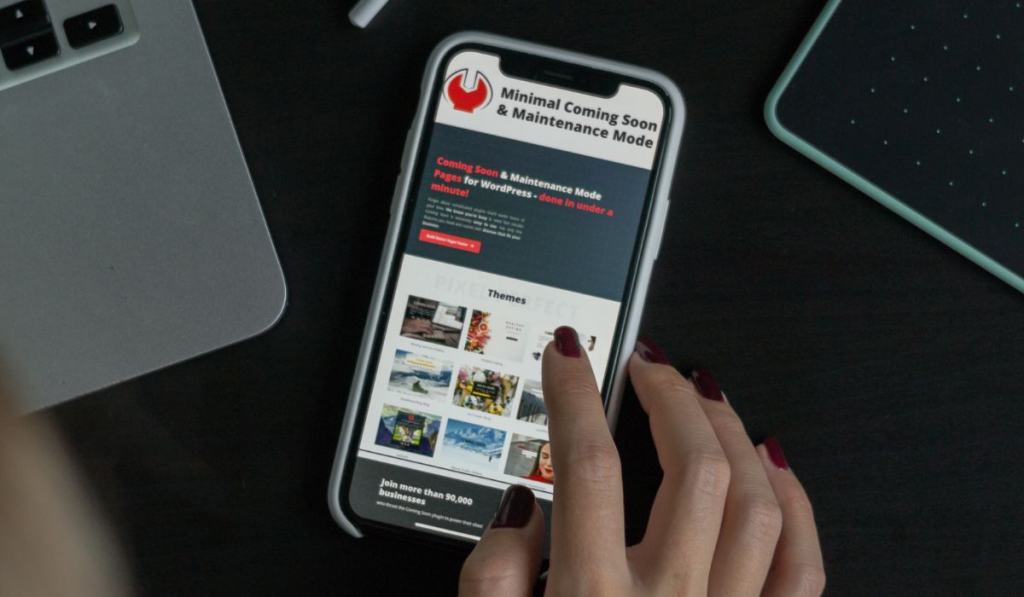 Woman using iPhone X to select a coming soon page template for her new WordPress site