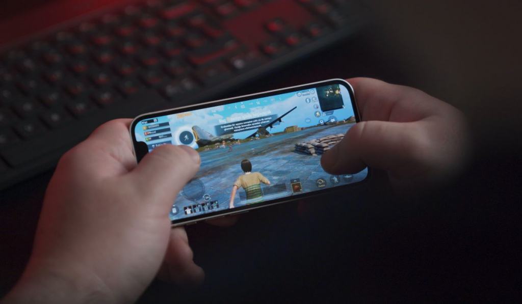 Young man playing PUBG Mobile with iPhone