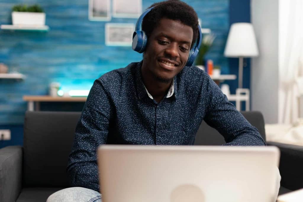 african american man wearing headphones using laptop Which Headphones Can Connect to 2 Devices
